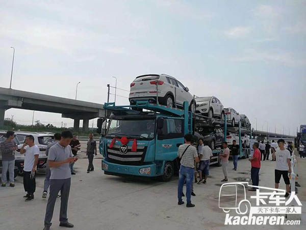 圍觀滿載的中置軸轎運車